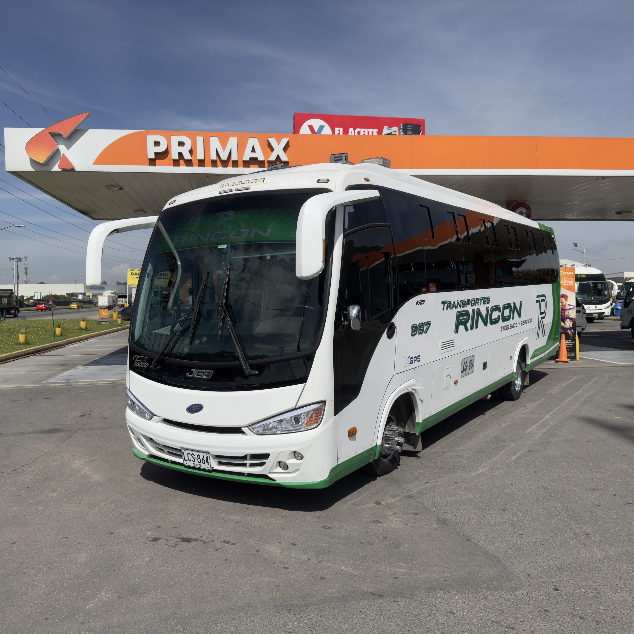 Empleado en estación de servicio suministrando urea automotriz a un camión.